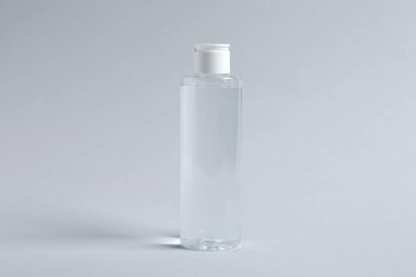 Açık gri arkaplanda bir şişe kozmetik ürünü