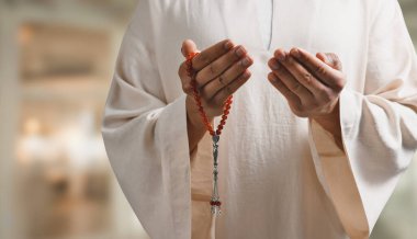 Misbaha 'lı Müslüman bir adam bulanık arka planda dua ediyor, yakın plan. Metin için alanı olan pankart tasarımı