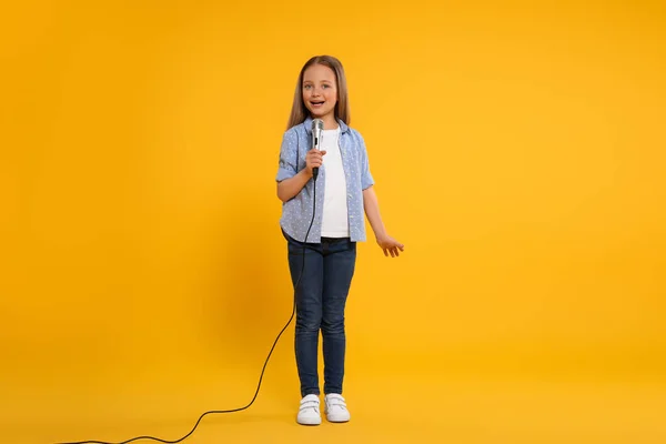 Χαριτωμένο Κοριτσάκι Μικρόφωνο Τραγουδά Κίτρινο Φόντο — Φωτογραφία Αρχείου