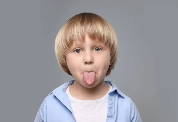 Netter Kleiner Junge Zeigt Seine Zunge Auf Grauem Hintergrund — Stockfoto