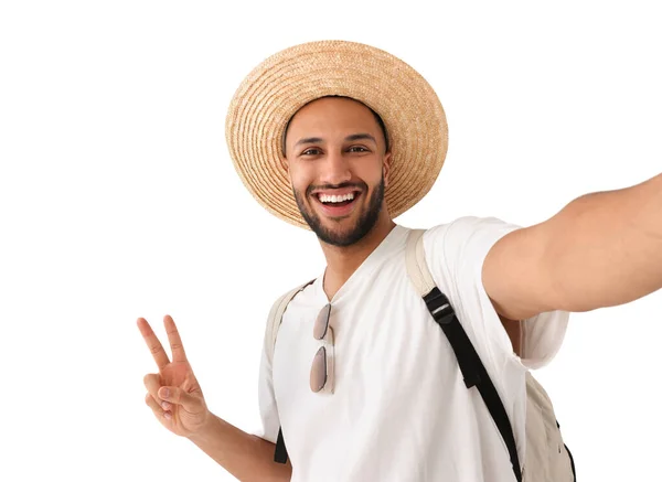 戴着草帽的年轻人带着自拍微笑 并在白色背景上显示出和平的迹象 — 图库照片