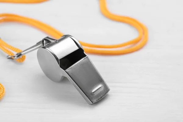 stock image One metal whistle with cord on white wooden table, closeup