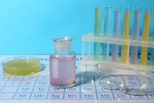 化学元素周期表上的安全玻璃 培养皿和不同液体的试管 — 图库照片