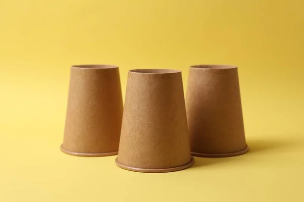 stock image Three paper cups on yellow background. Thimblerig game