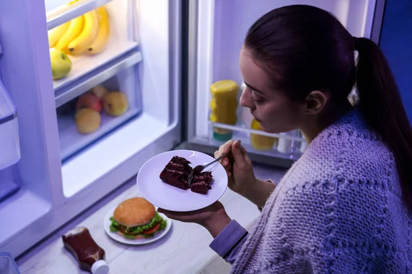 年轻女人晚上在厨房冰箱边吃蛋糕 坏习惯 — 图库照片