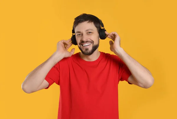 Homme Heureux Dans Les Écouteurs Profitant Musique Sur Fond Orange — Photo