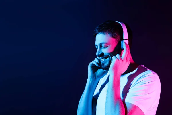 Handsome Man Headphones Enjoying Music Neon Lights Dark Blue Background — Stock Photo, Image