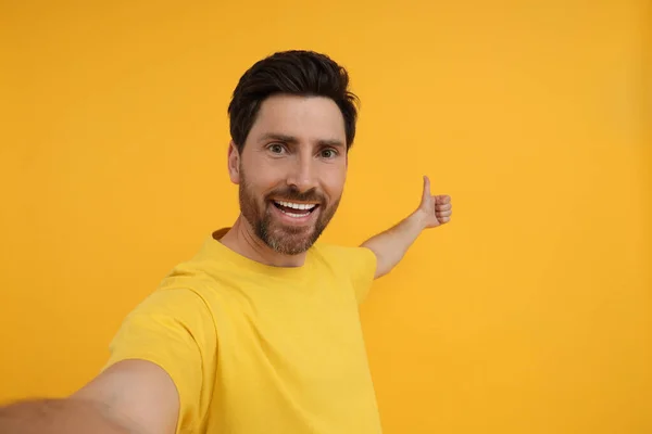 Smiling Man Taking Selfie Showing Thumbs Yellow Background Space Text — Stock Photo, Image