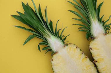 Sarı zemin üzerinde olgun ananas yarımları, düz yatıyordu.