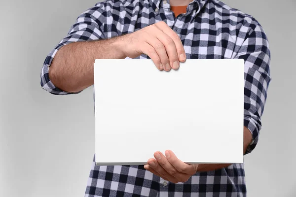 Mann Hält Blatt Papier Auf Hellgrauem Hintergrund Nahaufnahme Mockup Für — Stockfoto