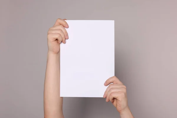 Woman Holding Sheet Paper Grey Background Closeup Mockup Design — Stock Photo, Image