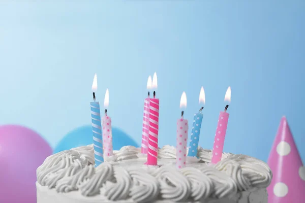 美味的蛋糕 点着蜡烛 淡蓝色背景的节日装饰 — 图库照片