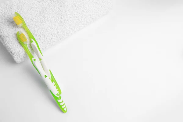 浅绿色的牙刷和白色背景的毛巾纸 顶视图 案文的篇幅 — 图库照片