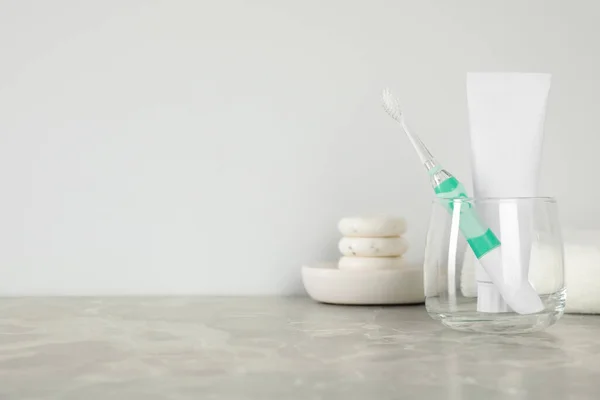 Electric Toothbrush Glass Tube Paste Light Grey Marble Table Space — Stock Photo, Image