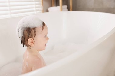 Evde küvette banyo yapan şirin bir bebek. Metin için boşluk
