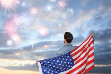 4 Temmuz - Amerika 'nın Bağımsızlık Günü. Birleşik Devletler bayrağı taşıyan bir adam havai fişeklerin keyfini çıkarıyor.