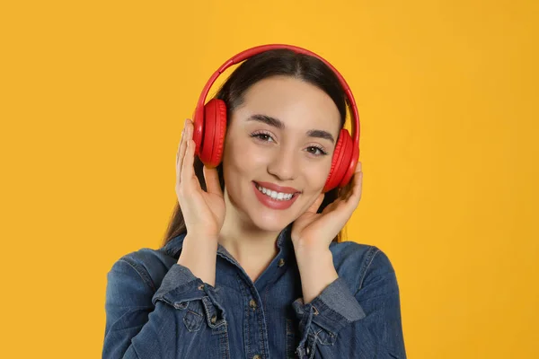 Πορτρέτο Της Ευτυχούς Γυναίκας Στα Ακουστικά Ακούγοντας Μουσική Πορτοκαλί Φόντο — Φωτογραφία Αρχείου