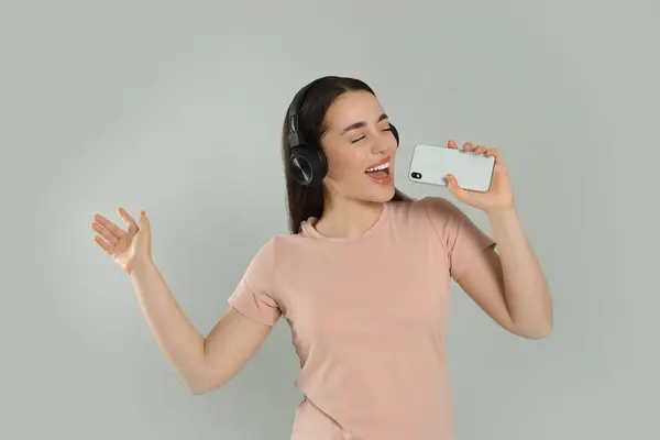 Ευτυχισμένη Γυναίκα Ακουστικά Που Απολαμβάνει Μουσική Και Τραγουδά Smartphone Γκρι — Φωτογραφία Αρχείου