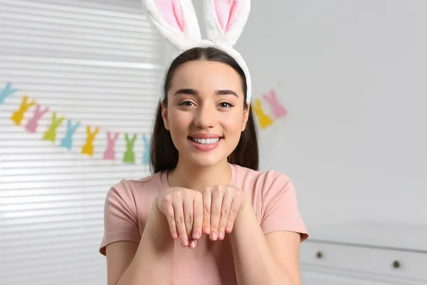 在装饰过的房间里戴着兔子耳朵头带的快乐女人 复活节庆祝活动 — 图库照片