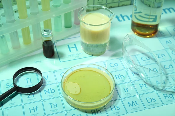 Verschiedene Laboreinrichtungen Mit Flüssigkeiten Und Schutzbrillen Auf Periodensystem Der Chemischen — Stockfoto