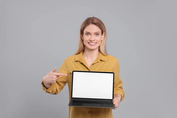 Šťastná Žena Ukazující Notebook Světle Šedém Pozadí — Stock fotografie