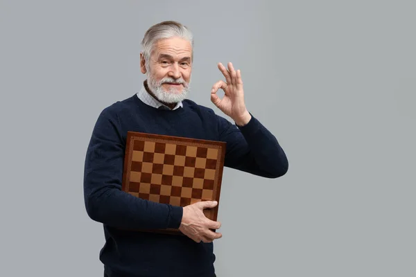 明るい灰色の背景に をジェスチャーを示すチェス盤の男 テキストのスペース — ストック写真
