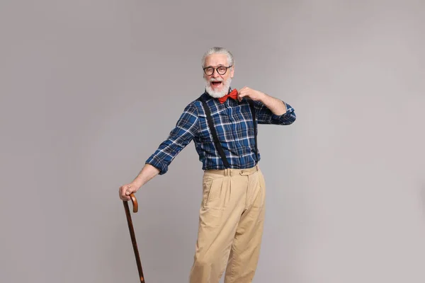 Веселый Пожилой Человек Тростью Сером Фоне — стоковое фото