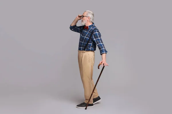 Senior Man Med Promenadkäpp Grå Bakgrund — Stockfoto