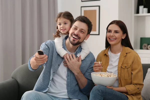 家庭で映画を見て幸せな家族 お父さんはリモコンでテレビチャンネルを変える — ストック写真