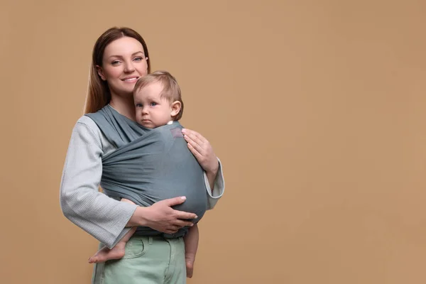 Madre Sosteniendo Hijo Una Envoltura Bebé Sobre Fondo Marrón Claro —  Fotos de Stock