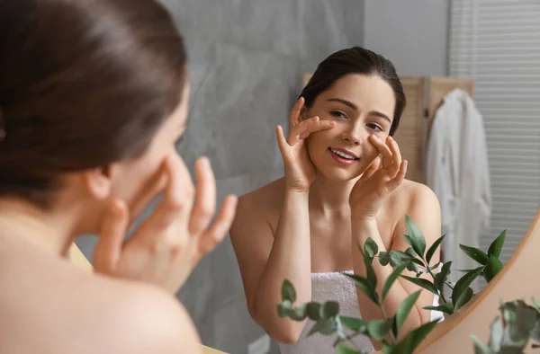 Ung Kvinna Masserar Sitt Ansikte Nära Spegeln Badrummet — Stockfoto