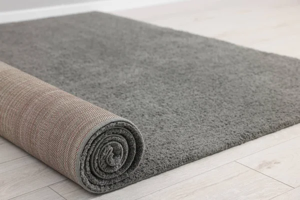 stock image Rolled grey carpet on floor in room, closeup