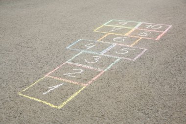 Açık havada asfalt üzerine renkli tebeşirle çizilmiş seksek.