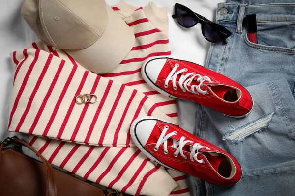 Ζεύγος Από Stylish Κόκκινα Sneakers Ρούχα Και Αξεσουάρ Λευκό Ύφασμα — Φωτογραφία Αρχείου