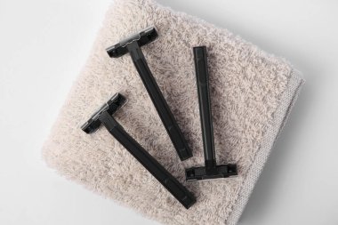 Beyaz zemin üzerinde jilet ve havlu, üst görünüm