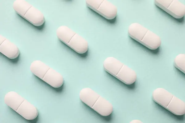 ミントの背景に白い錠剤フラットレイ — ストック写真