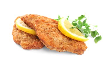 Limonlu lezzetli şnitzeller ve beyaz arka planda mikro yeşiller.
