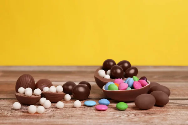 Deliciosos Huevos Chocolate Caramelos Sobre Mesa Madera Sobre Fondo Amarillo — Foto de Stock