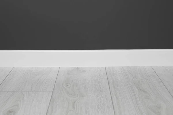 stock image White plinth on laminated floor near black wall indoors