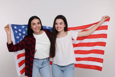 4 Temmuz - ABD 'nin Bağımsızlık Günü. Beyaz arka planda Amerikan bayrağı olan mutlu kadın ve kızı