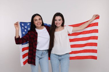 4 Temmuz - ABD 'nin Bağımsızlık Günü. Beyaz arka planda Amerikan bayrağı olan mutlu kadın ve kızı