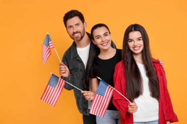 4 Temmuz - ABD 'nin Bağımsızlık Günü. Sarı arka planda Amerikan bayrakları olan mutlu bir aile