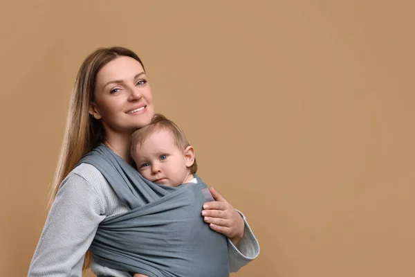 Moeder Houdt Haar Kind Baby Verpakking Lichtbruine Achtergrond Ruimte Voor — Stockfoto