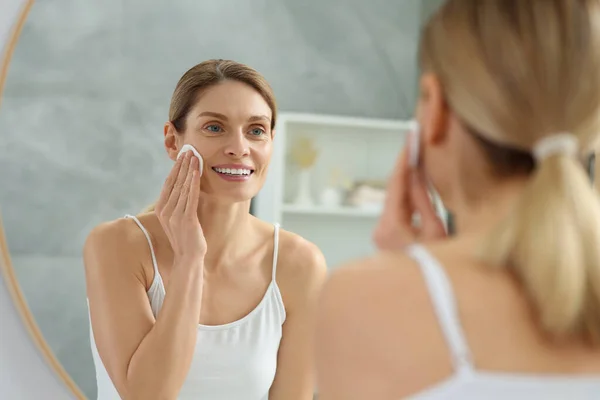 Vacker Kvinna Tar Bort Makeup Med Bomullspad Nära Spegeln Inomhus — Stockfoto