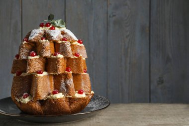 Lezzetli Pandoro Noel ağacı pastası pudra şekeri ve ahşap masada böğürtlen. Metin için boşluk