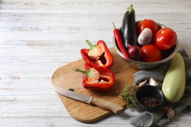 Lezzetli ratatouille pişiriyorum. Taze olgun sebzeler ve beyaz ahşap masada bir kase. Metin için boşluk