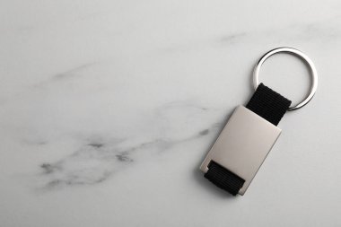 Beyaz mermer masada metal anahtarlık, üst görüş. Metin için boşluk