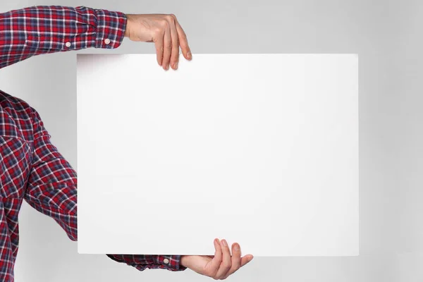 Man Holding Sheet Paper Grey Background Closeup Mockup Design — Stockfoto