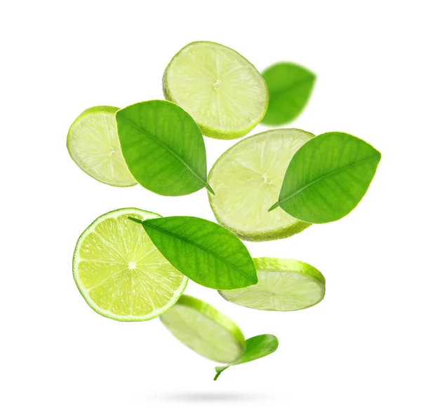 Friss Lime Szeletek Zöld Levelek Hulló Fehér Alapon — Stock Fotó