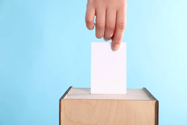 Woman Putting Her Vote Ballot Box Light Blue Background Closeup — Stock Photo, Image